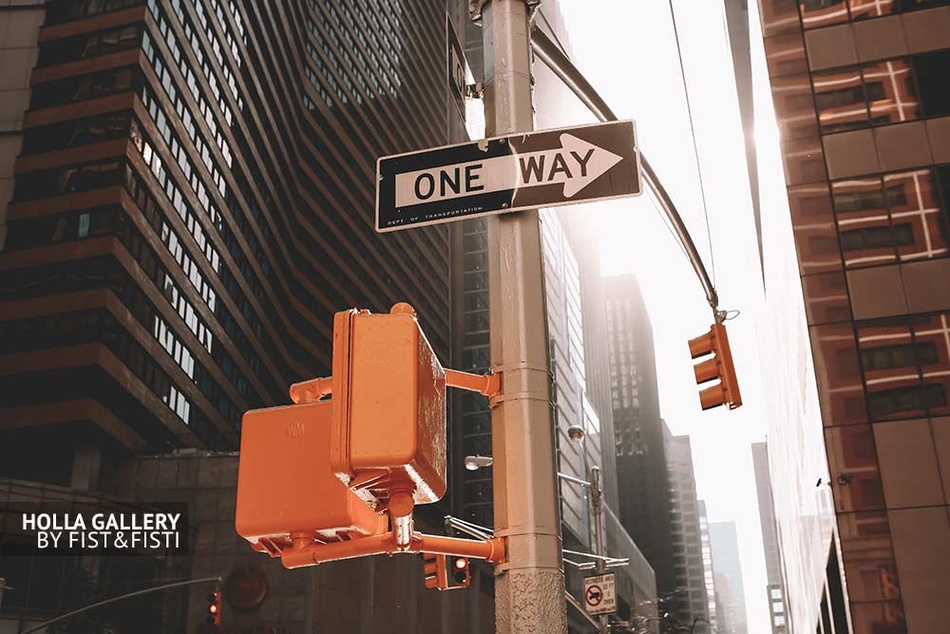 Дорожный знак One Way на светофоре перекрестка в Нью-Йорке среди небоскребов, фото картина. Мегаполис