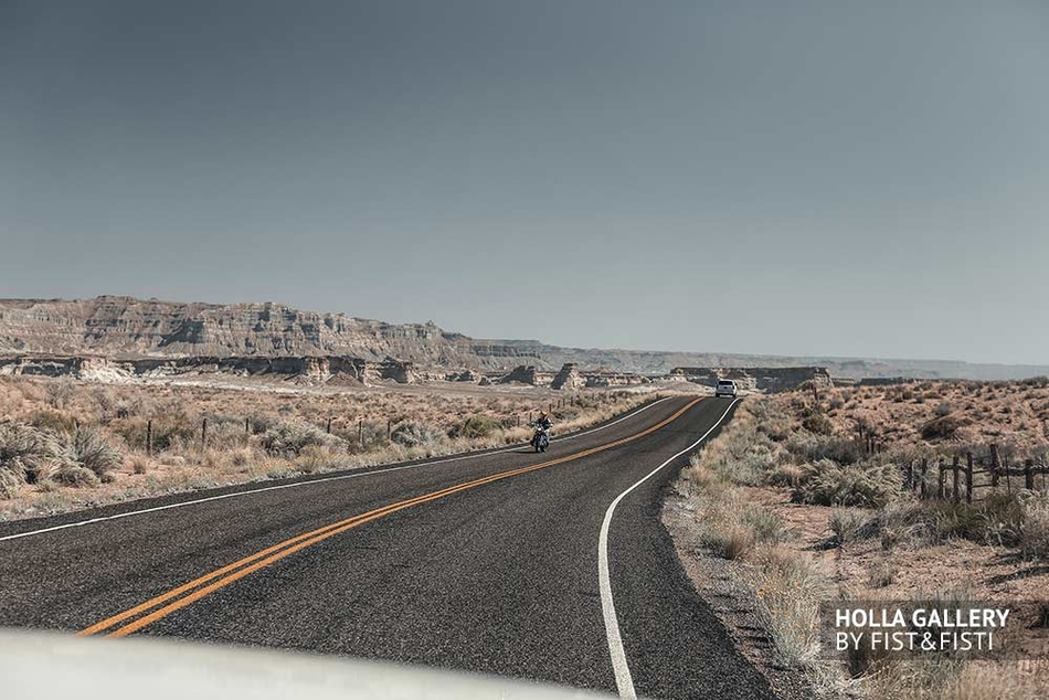 Мотоцикл и автомобиль на дороге посреди пустыни в Utah. Автострада в США