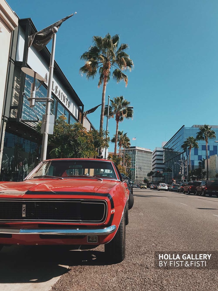 Красный Muscle car около пальм на дороге Лос-Анджелеса