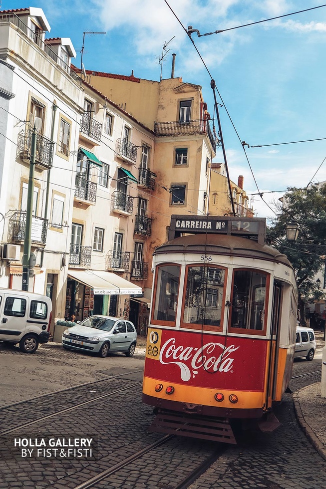 Желтый трамвай с надписью Coca-Cola в Лиссабоне.