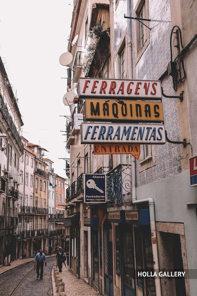 Узкая улочка Лиссабона с вывесками магазинов, фотообои для интерьера.