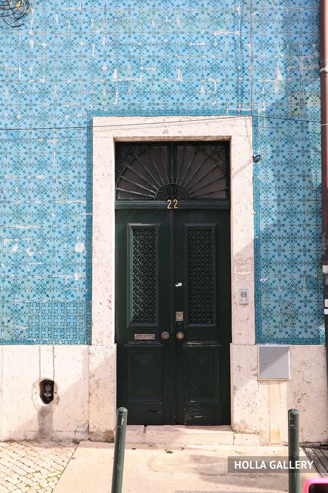 Зеленая дверь в голубой стене в Лиссабоне