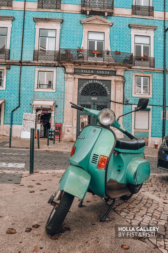 Зеленый мопед посреди улицы в Лиссабоне