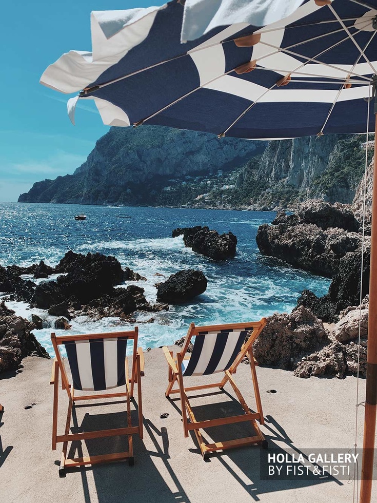 Скалистый пляж на Капри с шезлонгами. Фото для интерьера