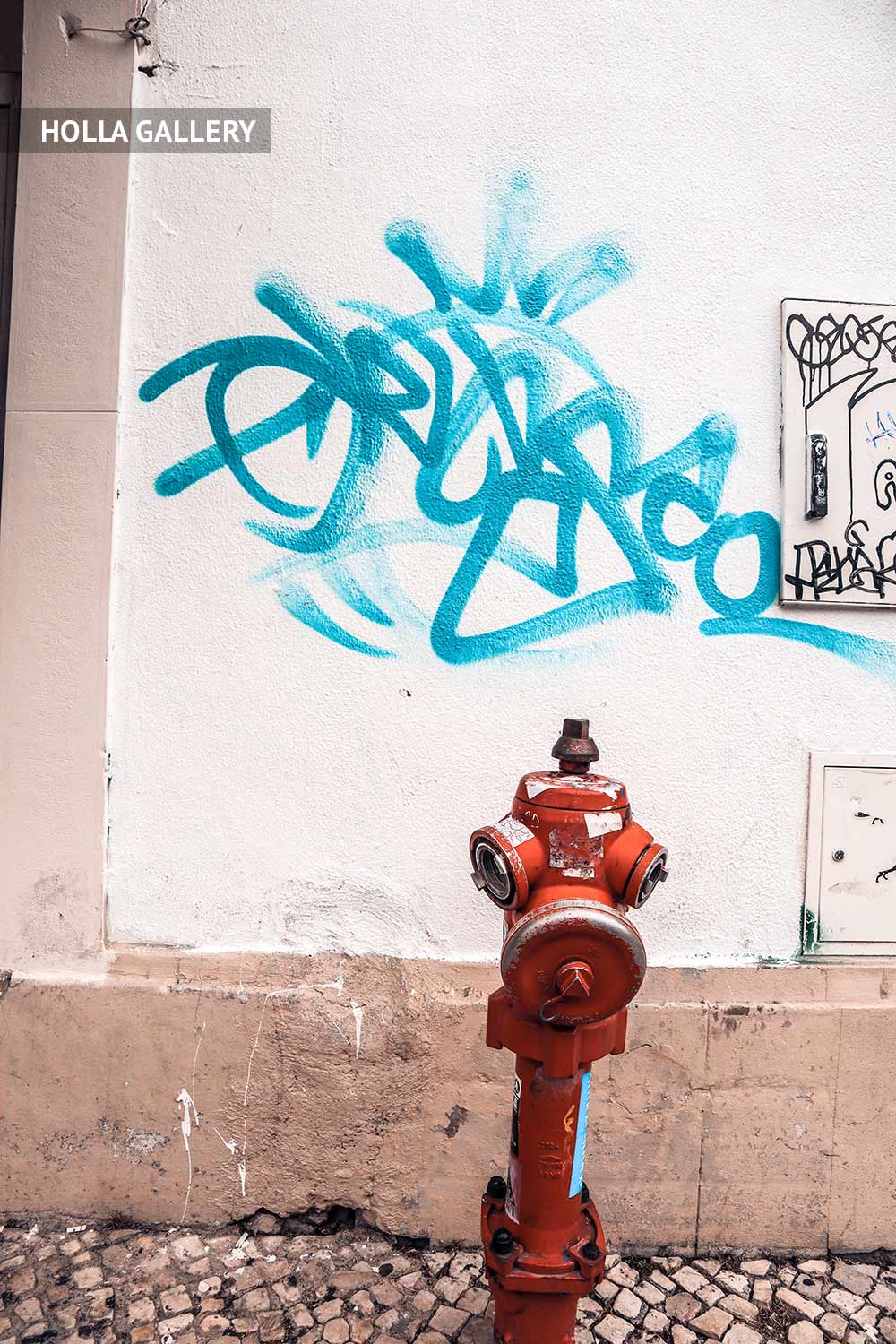 Гидрант у стены с граффити в Лиссабоне