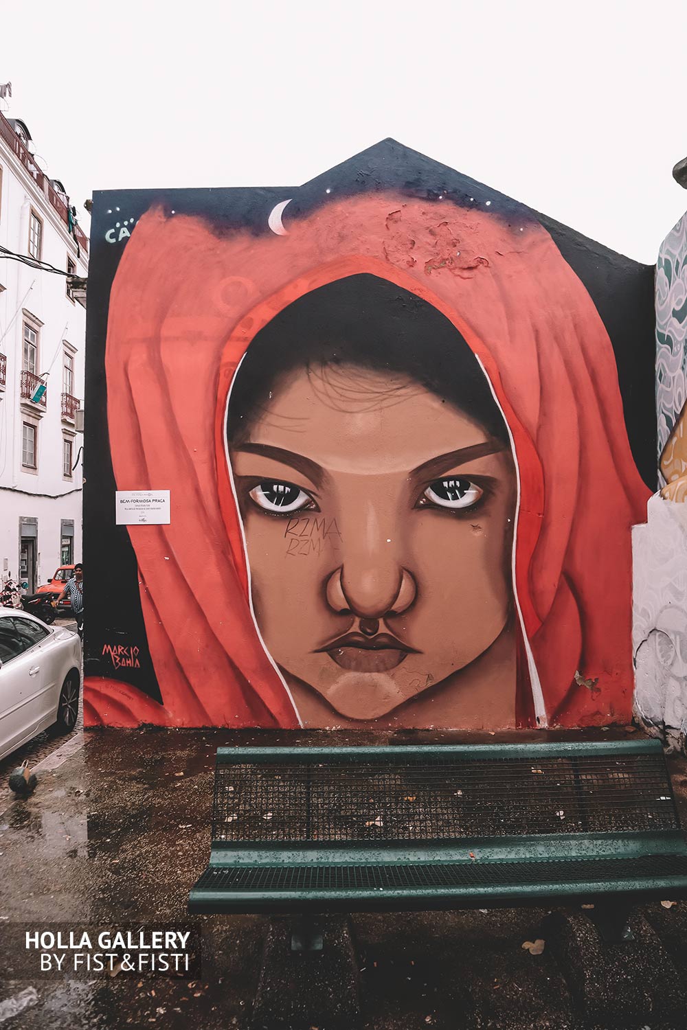 Большое граффити девушки в капюшоне на стене Лиссабона.