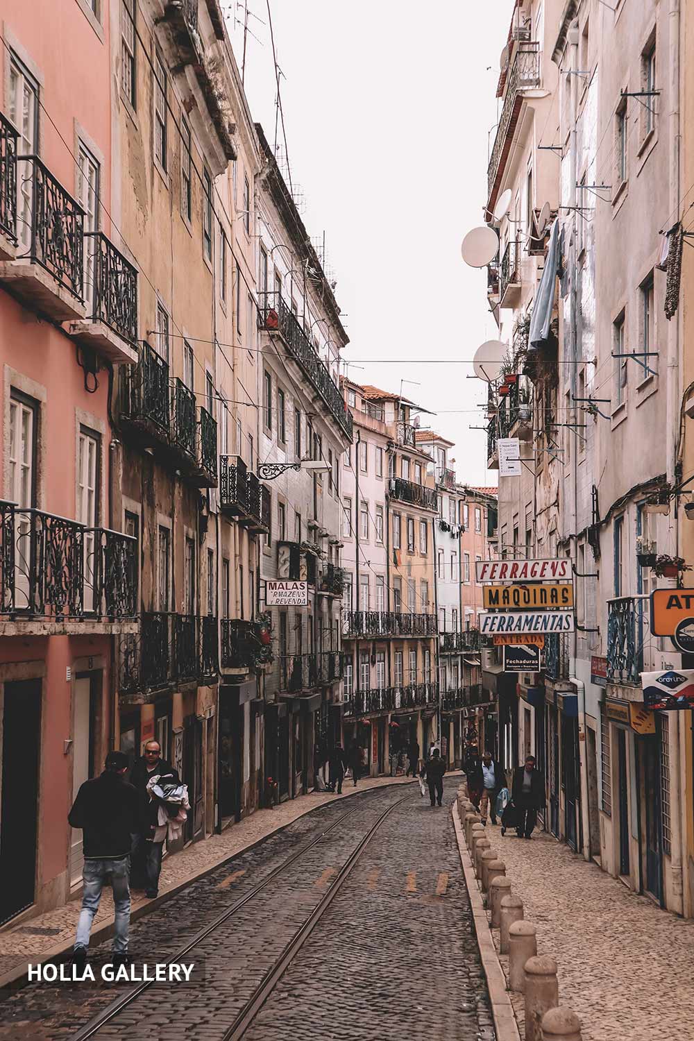 Узкая улица с трамвайными путями в Лиссабоне